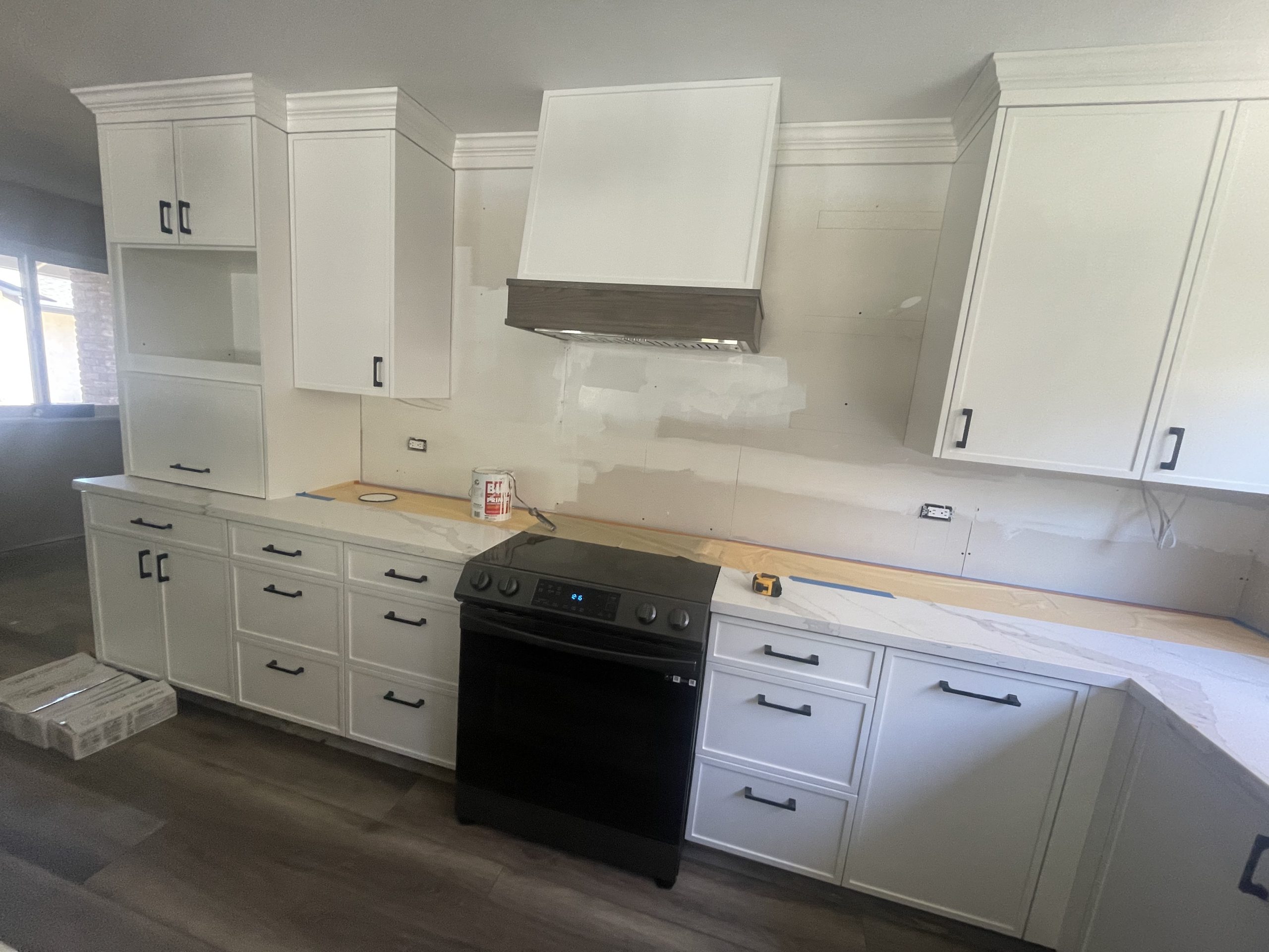 Kitchen with marble countertops and pendant lights taking shape